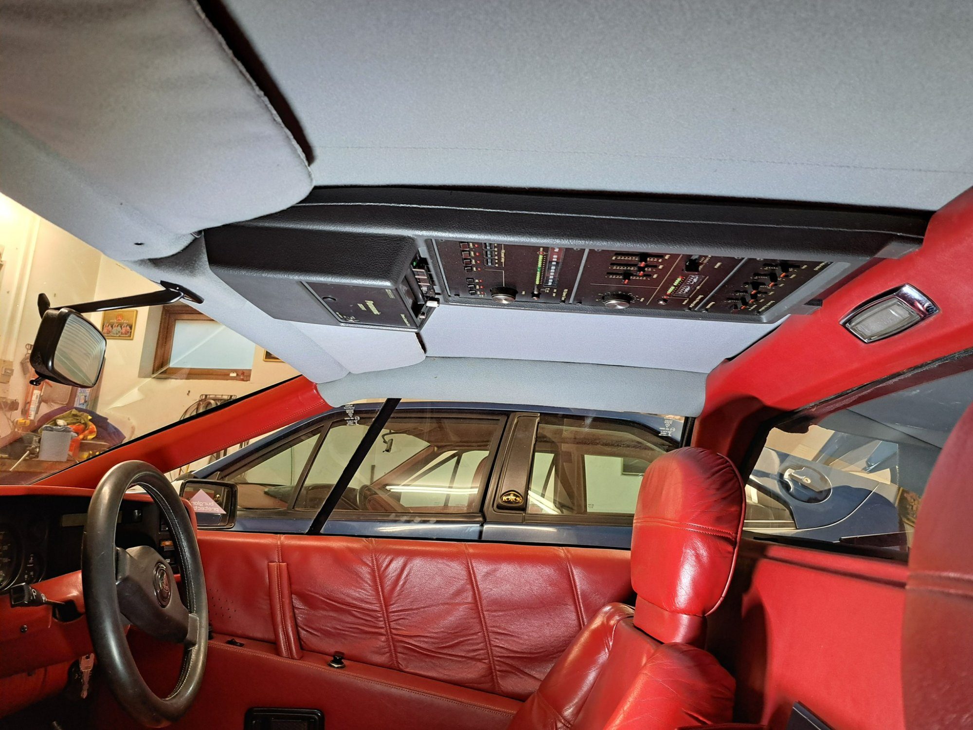 Rood leren interieur met Panasonic-stereo tegen het dak van de Essex Esprit Turbo